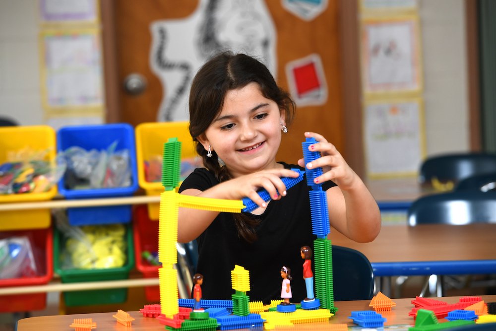 a student connects brightly colored pieces of a toy together 