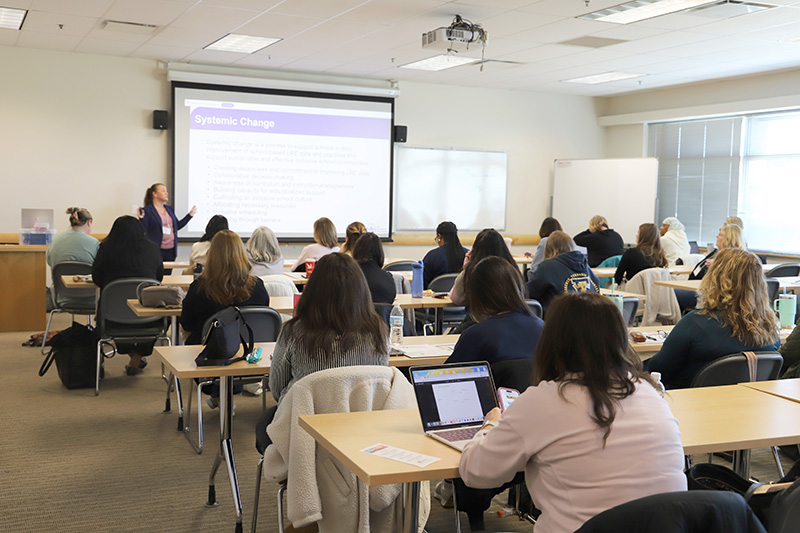 A presenter stands in front of a classroom filled with attendees at the 2025 Inclusion Institute.